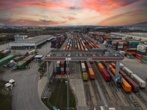 Specjalista ds. logistyki monitorujący trasę ciężarówek w nowoczesnym centrum spedycyjnym